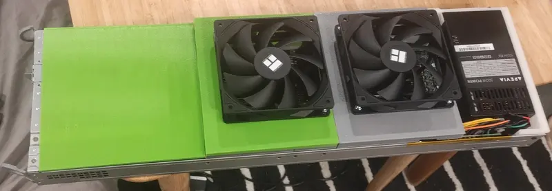 Photo of a DIY blade-style chassis on a table with a green 3D-printed cover, two top-mounted fans, and an ATX power supply on the right.