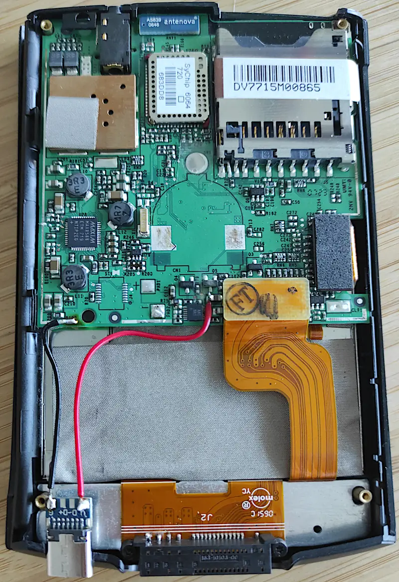 The internal view of the Palm TX PDA with its back cover removed, revealing the circuit board, and an added USB Type-C charging modification.